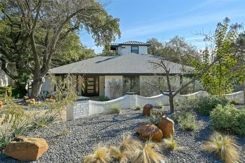 a backyard of a house with table and chairs under an umbrella