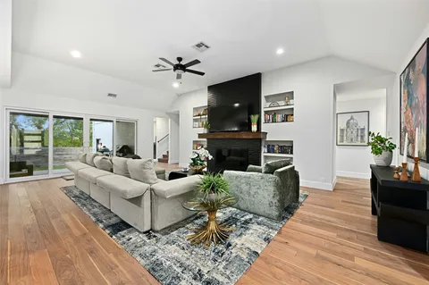 a living room with furniture a large window and a fireplace