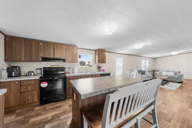 a kitchen with granite countertop a stove and white cabinets