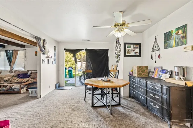 a living room with furniture a chandelier a large window and a flat screen tv