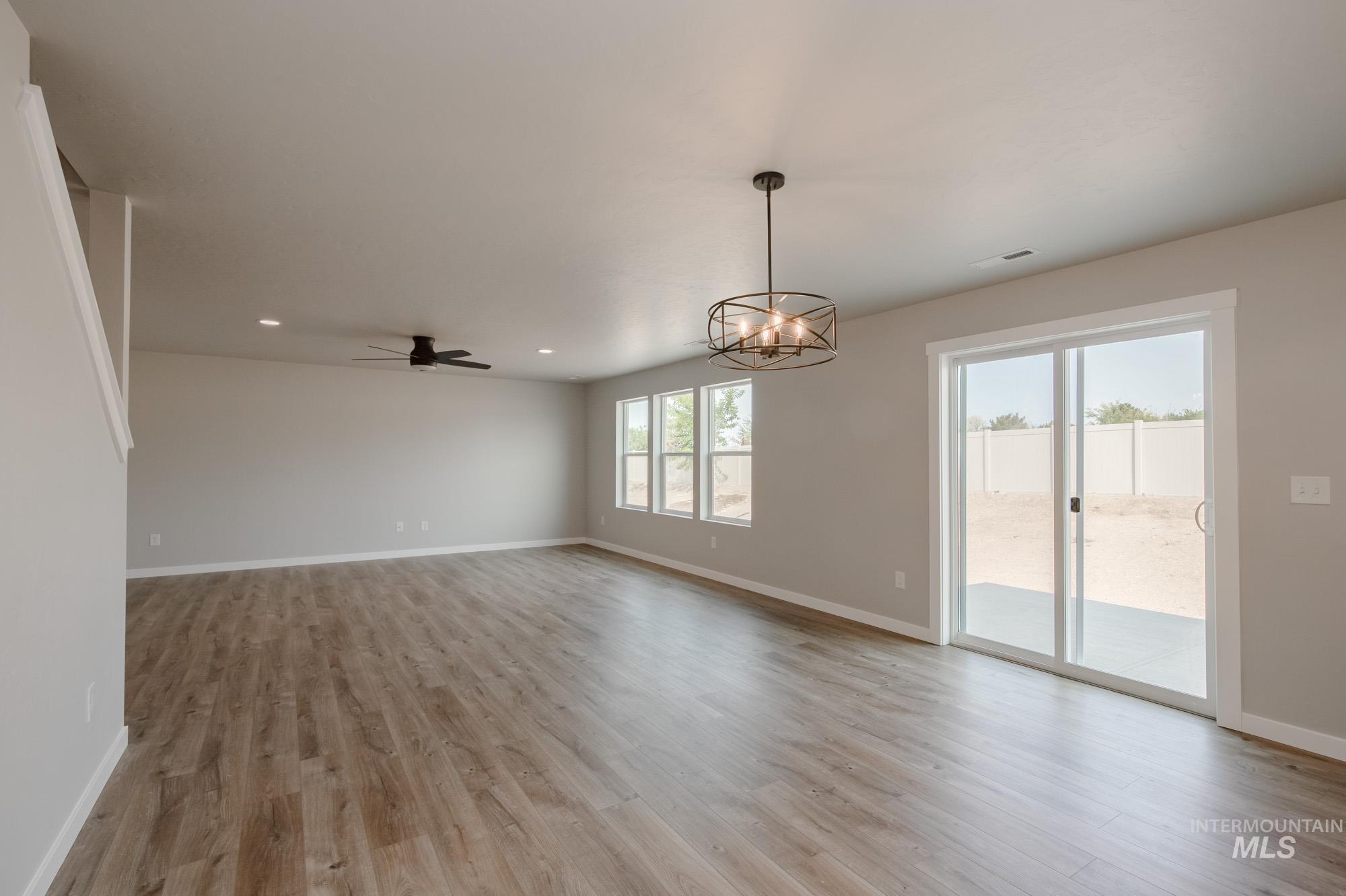 3304 West Morere Drive Meridian, ID 83642 - Photo 11 of 28 Unfurnished room with a chandelier, light wood-type flooring, ceiling fan, and recessed lighting