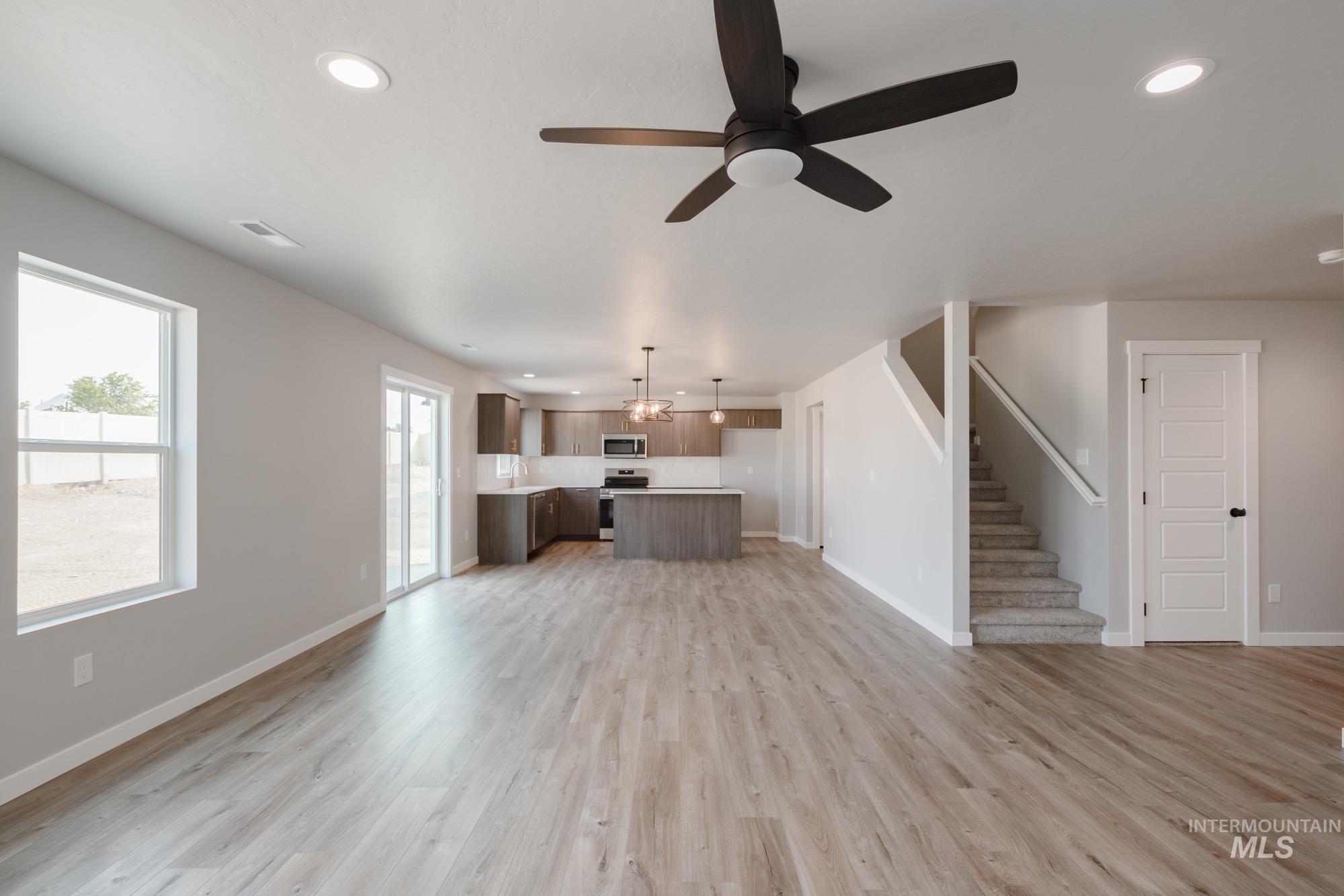 3304 West Morere Drive Meridian, ID 83642 - Photo 13 of 28 Unfurnished living room with recessed lighting, light wood-style flooring, a ceiling fan, and stairway