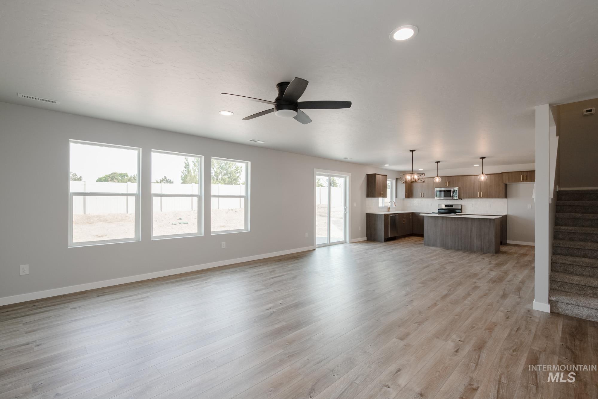 3304 West Morere Drive Meridian, ID 83642 - Photo 14 of 28 Unfurnished living room with light wood-style flooring, stairway, a ceiling fan, and recessed lighting