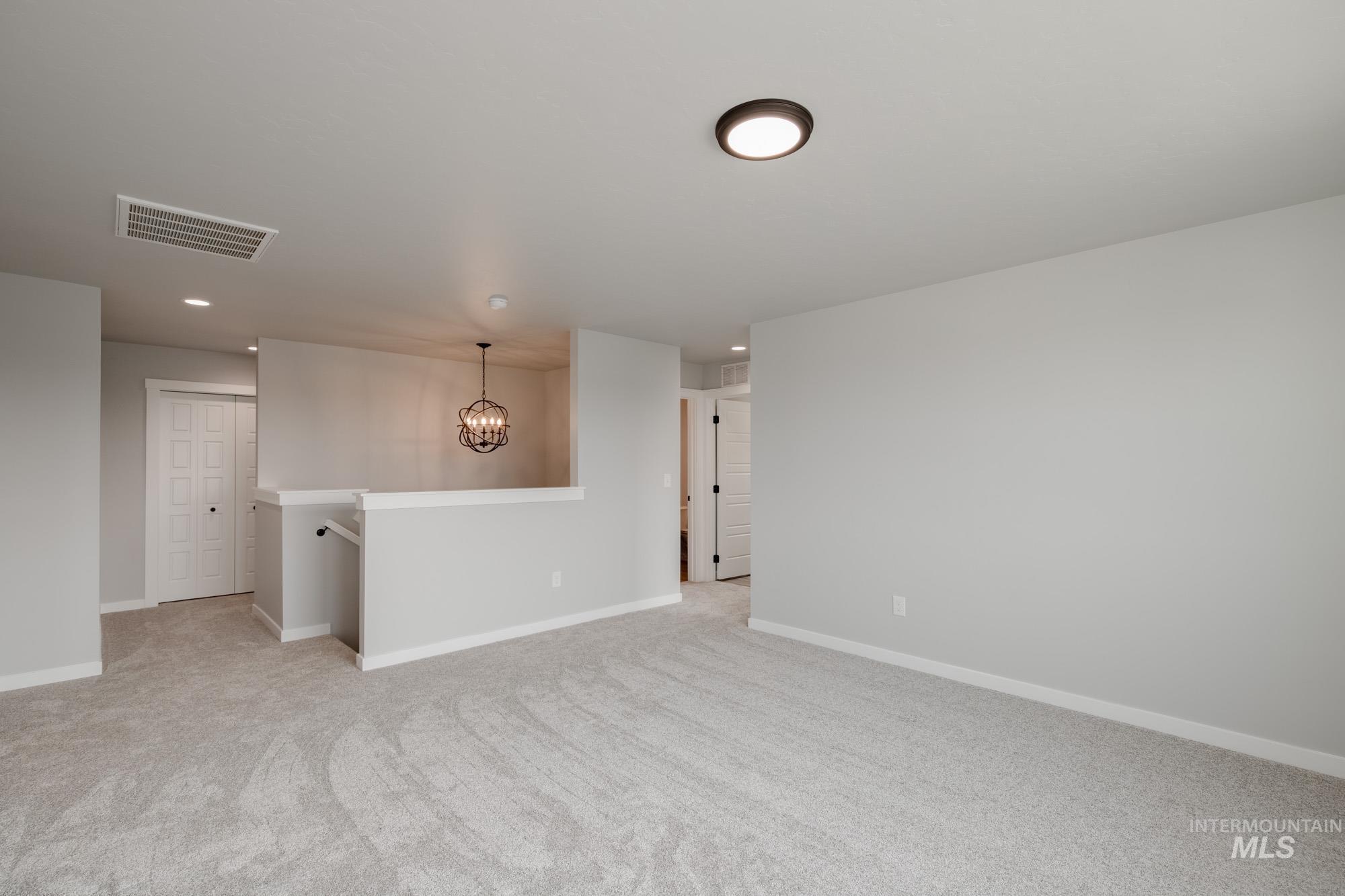3304 West Morere Drive Meridian, ID 83642 - Photo 24 of 28 Empty room featuring a chandelier, light colored carpet, and recessed lighting