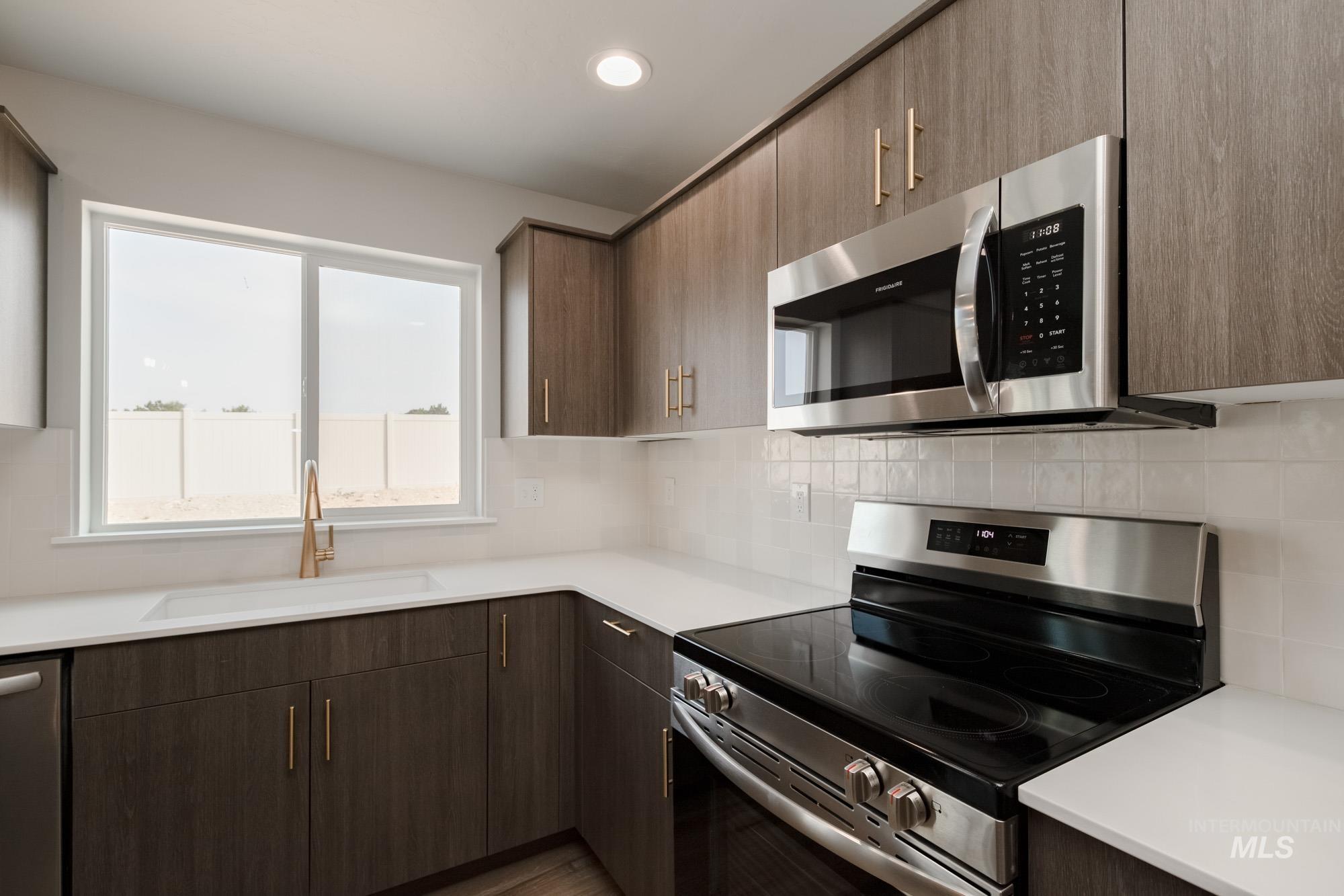 3304 West Morere Drive Meridian, ID 83642 - Photo 7 of 28 Kitchen featuring stainless steel appliances, tasteful backsplash, modern cabinets, recessed lighting, and dark brown cabinets