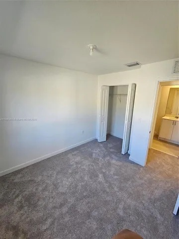 an empty room with stairs and a view of bedroom