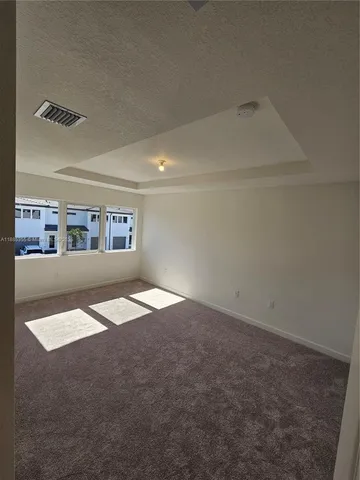 an empty room with kitchen view