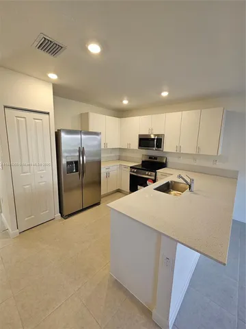 a kitchen with refrigerator cabinets and wooden floor