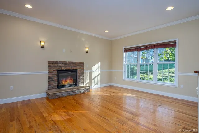 a view of empty room with wooden floor and fireplace
