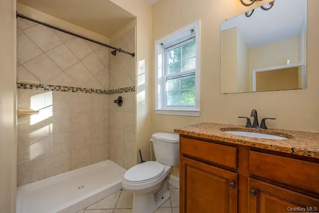 a bathroom with a granite countertop sink toilet and shower