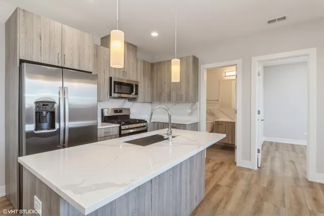 a kitchen with stainless steel appliances a refrigerator sink and microwave