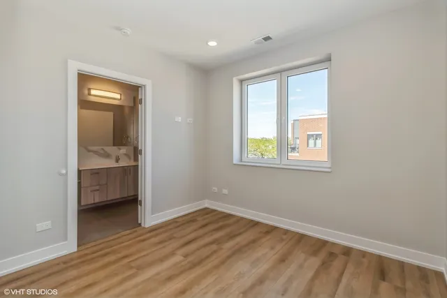 an empty room with a window and wooden floor