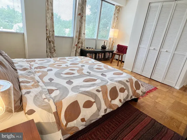 a bedroom with a bed with chair and window