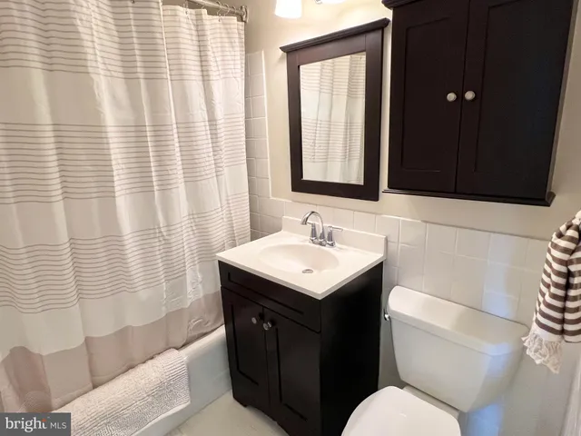 a bathroom with a sink toilet vanity and shower