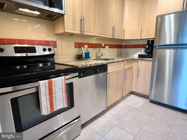 a kitchen with stainless steel appliances granite countertop a refrigerator stove and sink