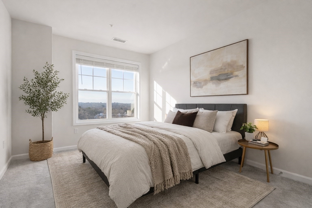 4 Stratton Drive, Unit 308 Woburn, MA 01801 - Photo 11 of 24 a bedroom with a large bed and a potted plant