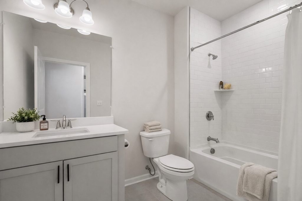 4 Stratton Drive, Unit 308 Woburn, MA 01801 - Photo 12 of 24 a bathroom with a sink a toilet and shower