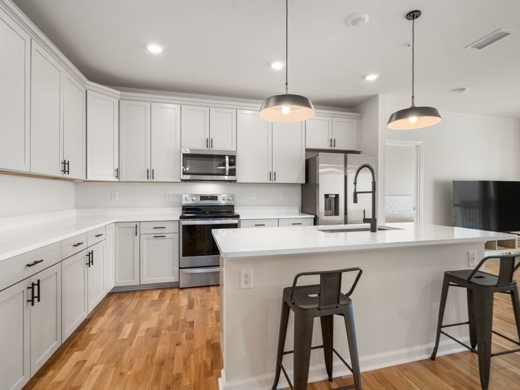 4 Stratton Drive, Unit 308 Woburn, MA 01801 - Photo 18 of 24 a kitchen with cabinets a sink and appliances