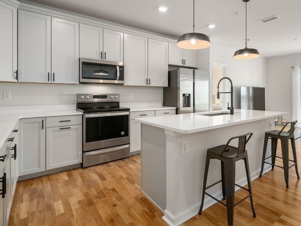 4 Stratton Drive, Unit 308 Woburn, MA 01801 - Photo 2 of 24 a kitchen with stainless steel appliances granite countertop a stove a sink and a microwave