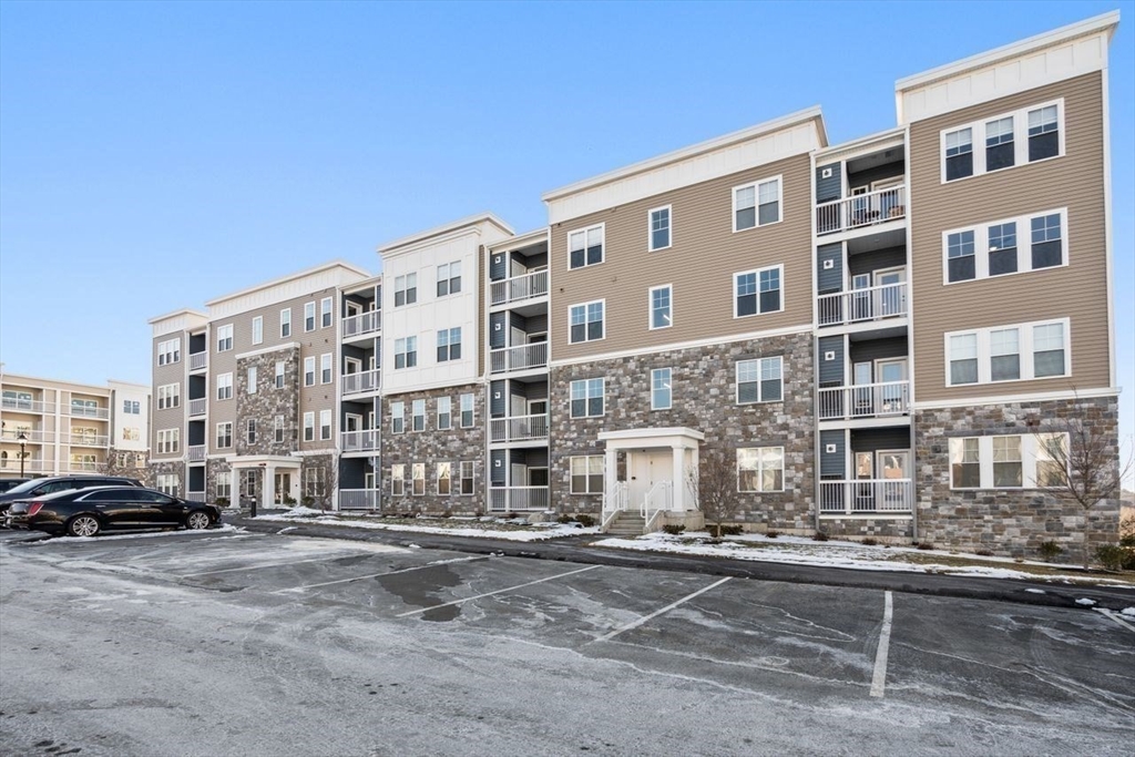 4 Stratton Drive, Unit 308 Woburn, MA 01801 - Photo 23 of 24 a front view of a building with lot of cars and trees