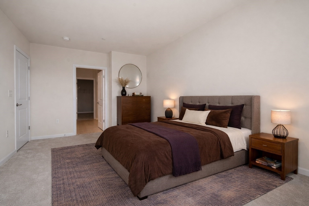 4 Stratton Drive, Unit 308 Woburn, MA 01801 - Photo 7 of 24 a bedroom with a bed and a lamp