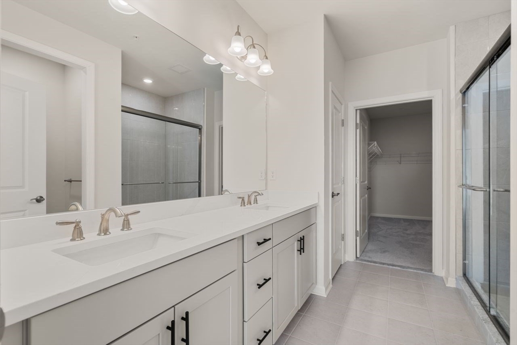 4 Stratton Drive, Unit 308 Woburn, MA 01801 - Photo 8 of 24 a bathroom with a sink double vanity and a mirror