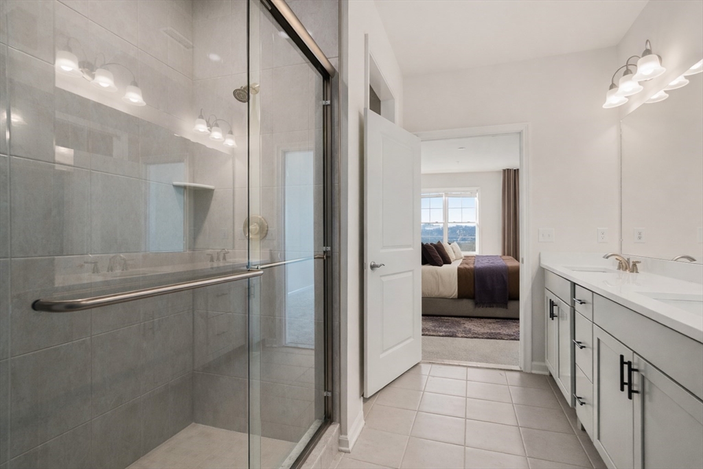 4 Stratton Drive, Unit 308 Woburn, MA 01801 - Photo 10 of 24 a en suite bathroom with a toilet a sink and mirror