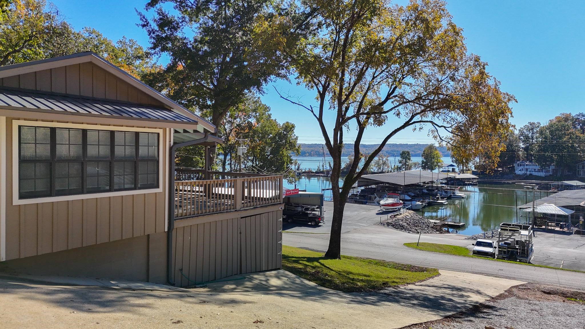 a view of a park with large trees and wooden fence