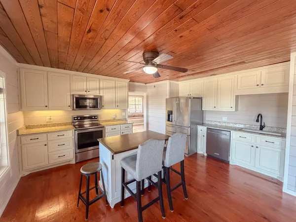 a kitchen with a sink white cabinets and stainless steel appliances