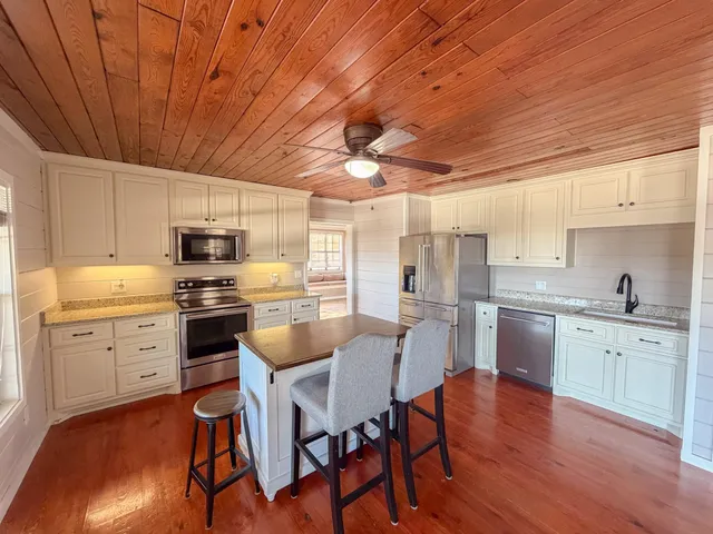 a kitchen with a sink white cabinets and stainless steel appliances
