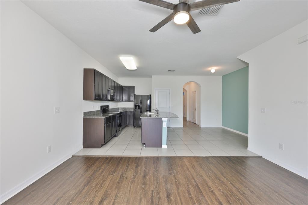 8969 Indigo Trail Loop Riverview, FL 33578 - Photo 12 of 41 a kitchen with stainless steel appliances a stove top oven a sink dishwasher and a refrigerator with wooden floor