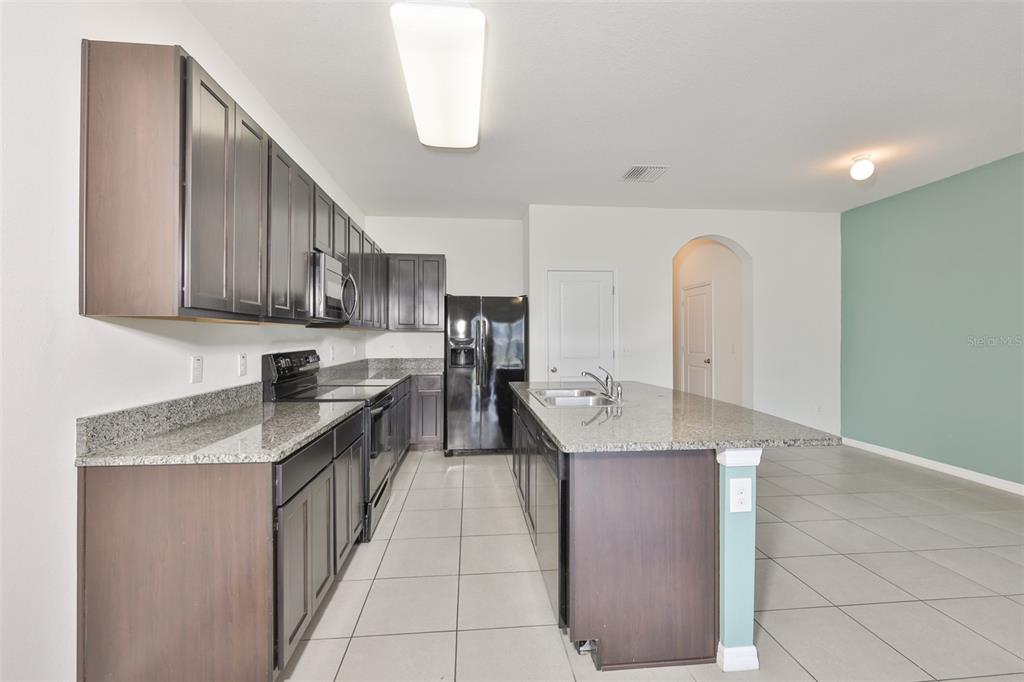 8969 Indigo Trail Loop Riverview, FL 33578 - Photo 14 of 41 a kitchen with stainless steel appliances granite countertop a sink a stove and a refrigerator