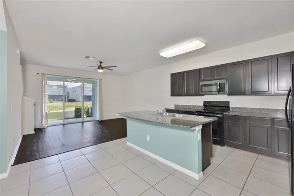 a kitchen with stainless steel appliances granite countertop a stove a sink and a refrigerator