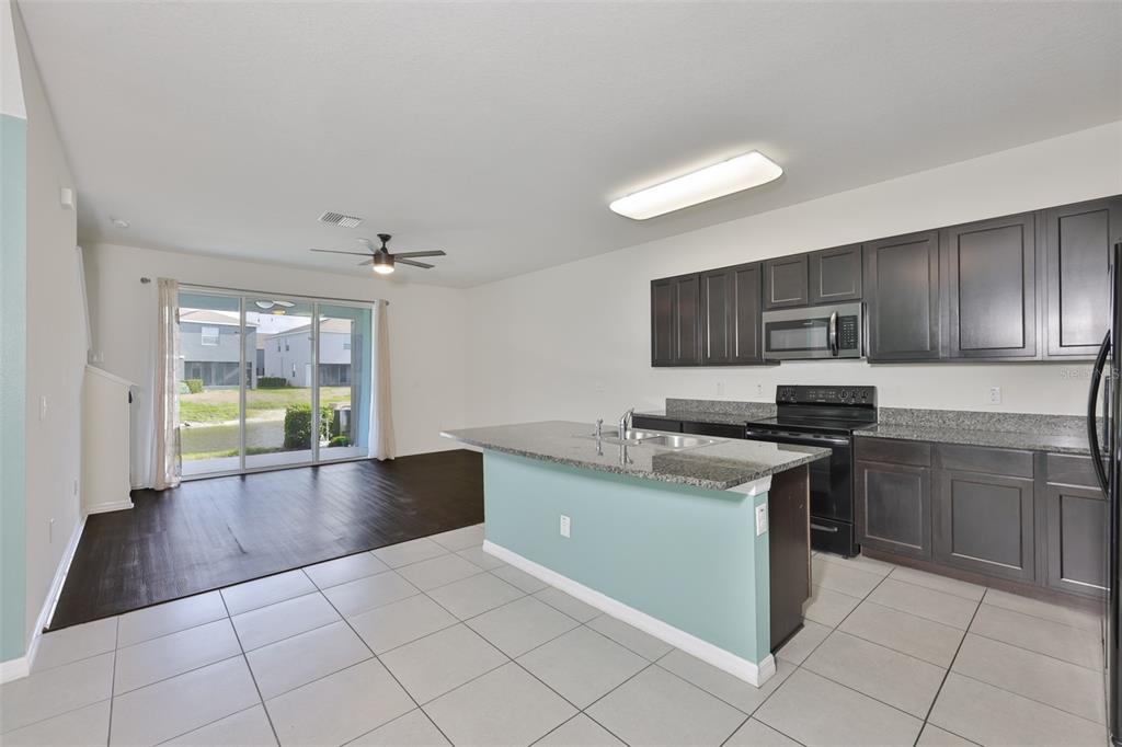 8969 Indigo Trail Loop Riverview, FL 33578 - Photo 7 of 41 a kitchen with stainless steel appliances granite countertop a stove a sink and a refrigerator