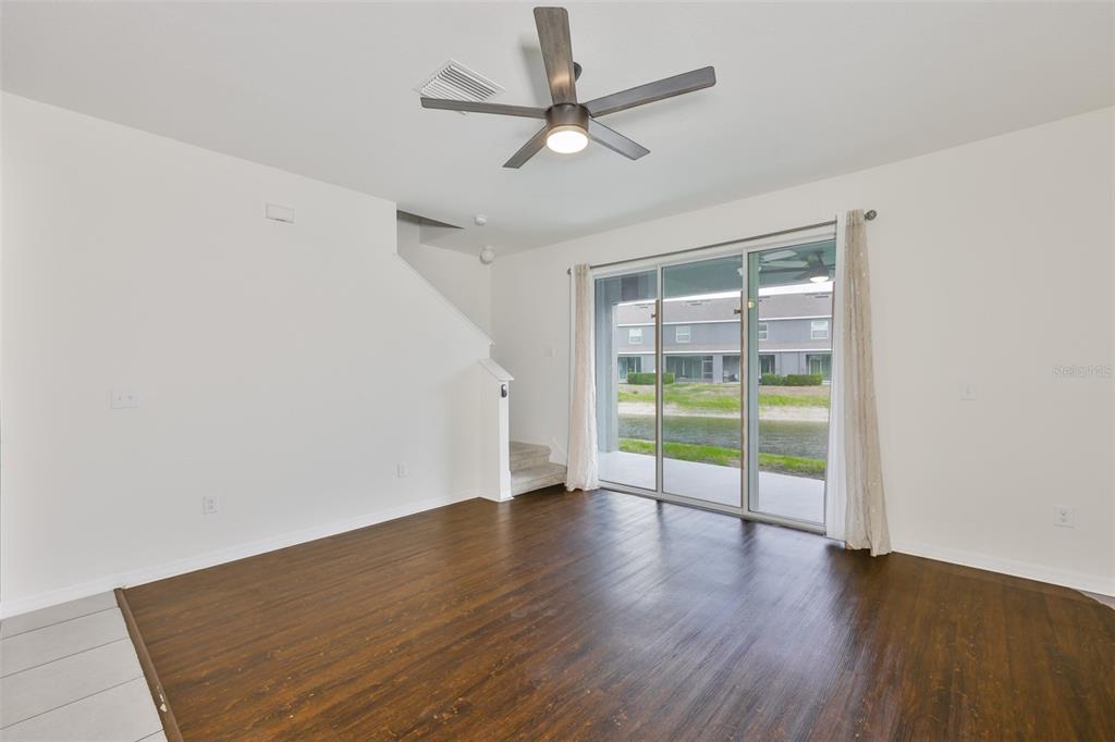 8969 Indigo Trail Loop Riverview, FL 33578 - Photo 10 of 41 an empty room with wooden floor and a ceiling fan