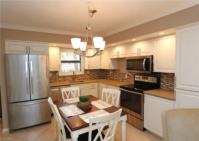 a kitchen with a center island refrigerator wooden floor and cabinets