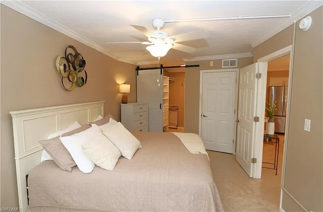 a bedroom with a large bed and a chandelier