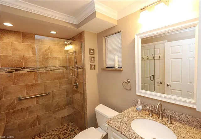a bathroom with a granite countertop sink toilet a mirror and shower