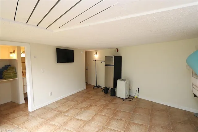 a view of a livingroom with a flat screen tv and refrigerator