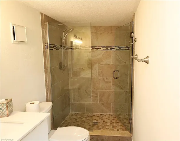 a bathroom with a shower toilet and sink