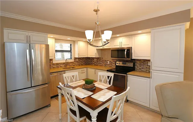 a kitchen with a refrigerator a stove a sink and a microwave