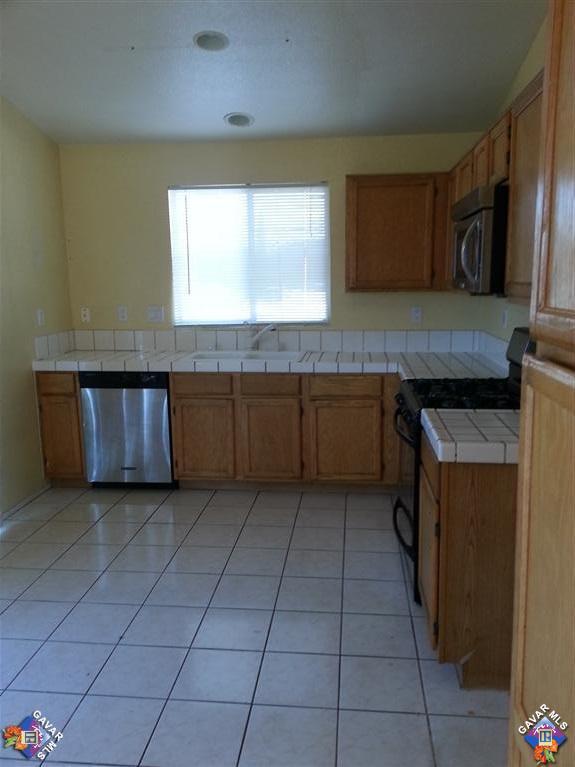 37033 Boxleaf Road Palmdale, CA 93550 - Photo 3 of 15 a kitchen with stainless steel appliances granite countertop a stove a sink and a microwave