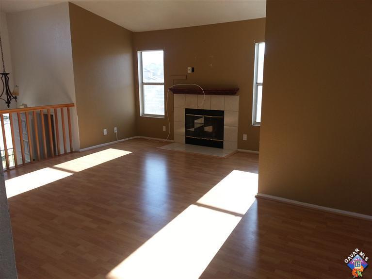 37033 Boxleaf Road Palmdale, CA 93550 - Photo 4 of 15 a view of an empty room with wooden floor fireplace and a window