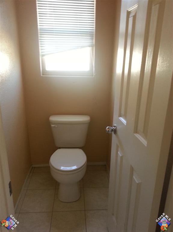 37033 Boxleaf Road Palmdale, CA 93550 - Photo 9 of 15 a white toilet sitting in a bathroom next to a window