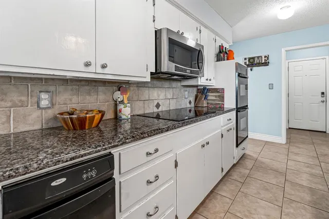 a kitchen with stainless steel appliances granite countertop a sink and a stove