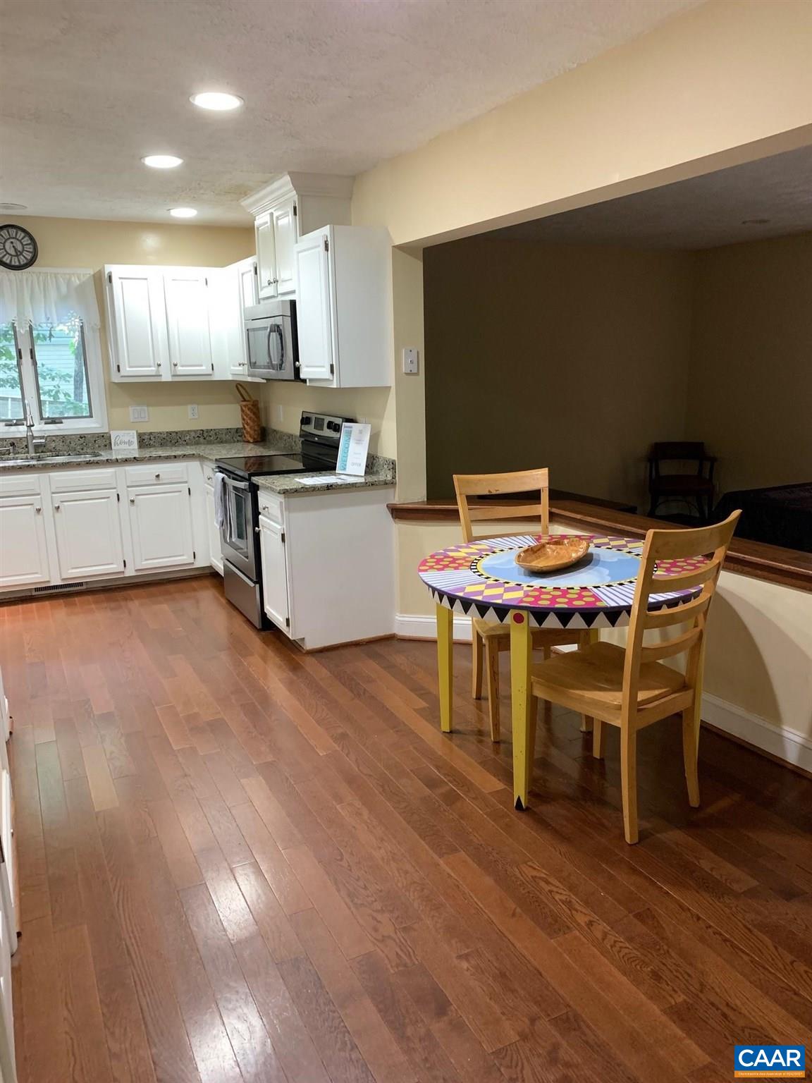 7 Stonewall Road Palmyra, VA 22963 - Photo 15 of 55 a kitchen with stainless steel appliances kitchen island granite countertop a sink dishwasher a stove a dining table and chairs with wooden floor