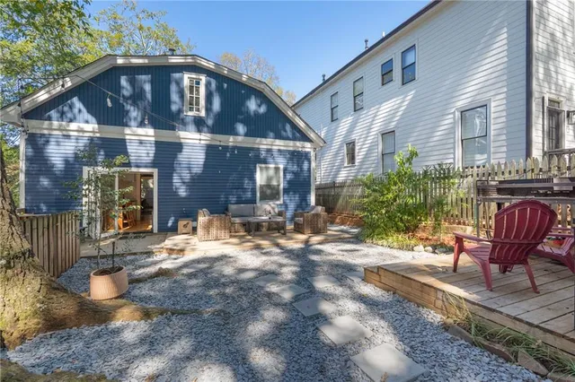 a view of backyard with outdoor seating and trees