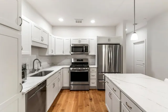 a kitchen with a sink a stove a microwave and refrigerator