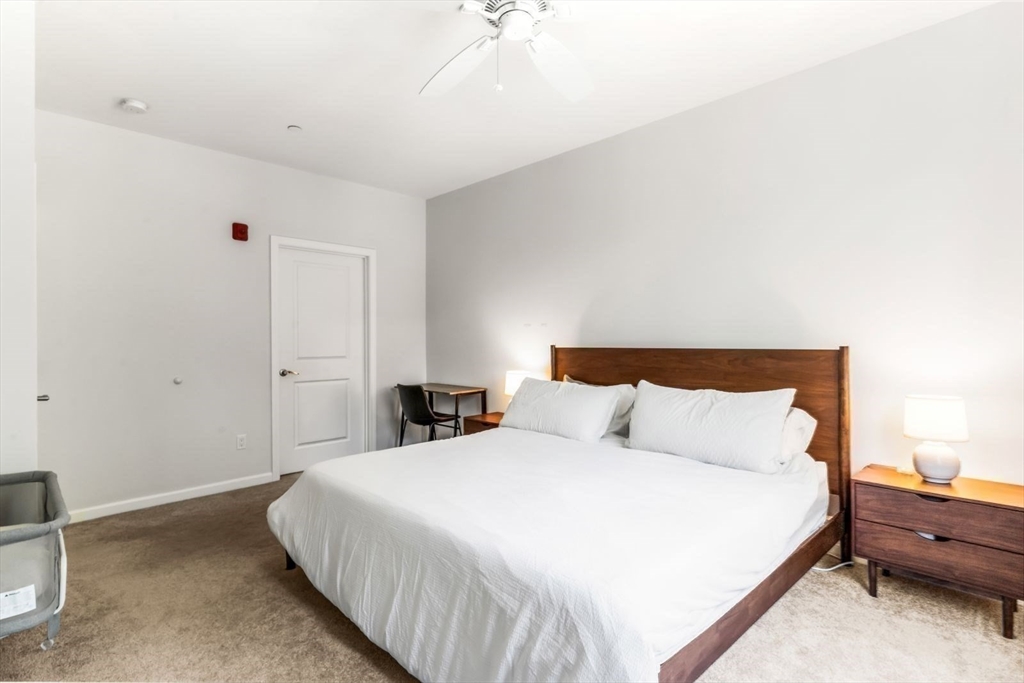 60 Coppersmith Way, Unit 304 Canton, MA 02021 - Photo 11 of 42 a bedroom with bed and a chandelier