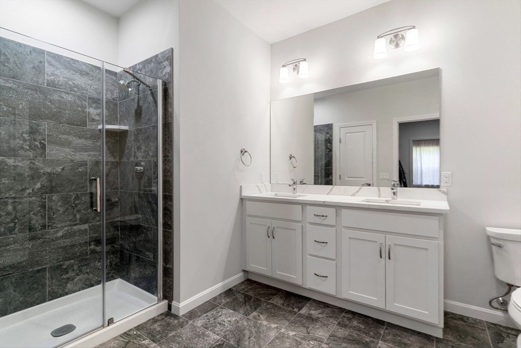 60 Coppersmith Way, Unit 304 Canton, MA 02021 - Photo 16 of 42 a bathroom with a granite countertop sink a mirror and a shower
